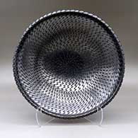 A large open glossy black bowl with a notched rim and decorated on the inside with a tooled geometric design
 by Reynaldo Quezada of Mata Ortiz and Casas Grandes