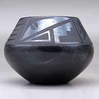 A black on black bowl decorated above the shoulder with a four-panel bat wing, kiva step and geometric design, click or tap to see a larger version