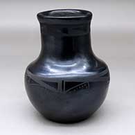 A black on black water jar decorated with bands of geometric design around the shoulder and around the upper neck
 by Carmelita Dunlap of San Ildefonso