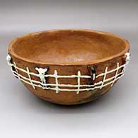 An open brown bowl decorated with a band of appliqued livestock at a fence
 by Silas Claw of Dineh
