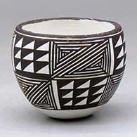 A miniature black on white jar decorated with a six panel fineline and geometric design
 by Lucy Lewis of Acoma