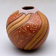 A polychrome seed pot decorated with four panels of carved melon shape and four panels of sgraffito butterfly and geometric design
 by Aaron Cajero Jr of Jemez