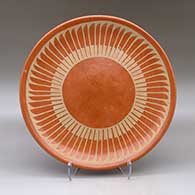 A buff on red plate decorated with a ring of feathers geometric design
 by Carmelita Dunlap of San Ildefonso