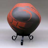 A red on brown jar decorated with a three-panel bird element and geometric design, click or tap to see a larger version