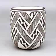 A black on white jar decorated with a lightning bolt and fineline geometric design
 by Carmel Lewis of Acoma