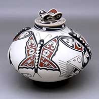 A lidded polychrome jar decorated with appliques, butterflies and geometric design with a butterfly on the lid
 by Hector Gallegos Sr of Mata Ortiz and Casas Grandes