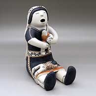 A sitting grandmother storyteller figure with two children
 by Helen Cordero of Cochiti