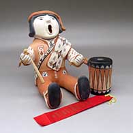 A sitting and singing drummer figure with a drum and drumstick in hand, Second Place ribbon from 1981 Santa Fe Indian Market
 by Ada Suina of Cochiti