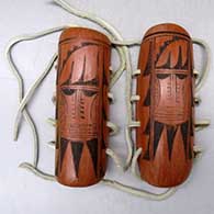 A pair of black on red hair ties decorated with a bird element and geometric design
 by Unknown of Hopi