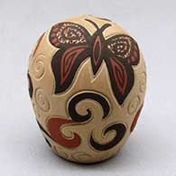 A miniature polychrome seed pot decorated with a lightly carved, sgraffito and painted butterfly, spiral and geometric design
 by Glendora Fragua of Jemez