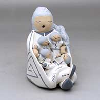 A sitting grandmother storyteller figure wearing a manta with four children
 by Chris Teller of Isleta