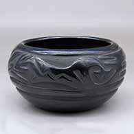 A black bowl carved with a stylized avanyu design around the body
 by Legoria Tafoya of Santa Clara