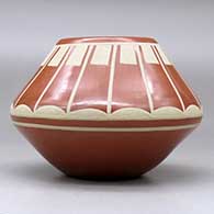 A buff on red jar decorated with a band of geometric design above the shoulder, click or tap to see a larger version