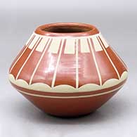 A buff on red jar decorated with a band of geometric design above the shoulder
 by Albert and Josephine Vigil of San Ildefonso