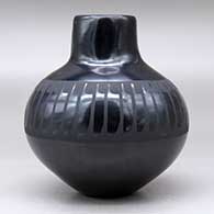 A black on black jar with a raised rim and decorated around the shoulder with a band of feathers design, click or tap to see a larger version