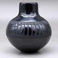 A black on black jar with a raised rim and decorated around the shoulder with a band of feathers design, click or tap to see a larger version