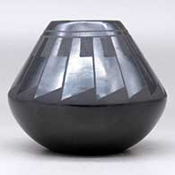 A black on black jar decorated with a ring of feathers design above the shoulder, click or tap to see a larger version
