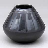 A black on black jar decorated with a ring of feathers design above the shoulder
 by Martha Appleleaf of San Ildefonso