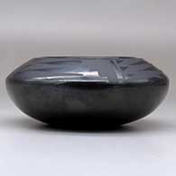 A small black on black bowl decorated with a four-panel bat wing and geometric design above the shoulder, click or tap to see a larger version