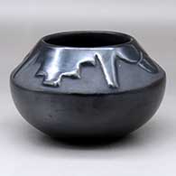 A black bowl carved with a four-panel geometric design above the shoulder
 by Rose Gonzales of San Ildefonso