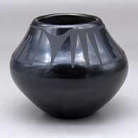 A black on black jar decorated above the shoulder with a four-panel bat wing and geometric design
 by Adam and Santana Martinez of San Ildefonso