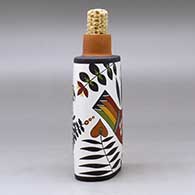 A polychrome flask with a corn cob stopper and decorated with a parrot, plant and geometric design, click or tap to see a larger version