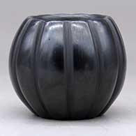 A small black melon bowl carved with 12 ribs, click or tap to see a larger version