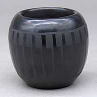 A small black bowl decorated around the shoulder with a ring of feathers design
 by Marvin and Frances Martinez of San Ildefonso