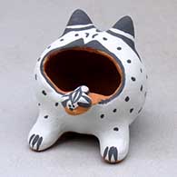 A sitting frog figure with a dragonfly on its tongue
 by Martha Arquero of Cochiti