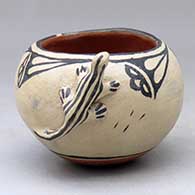 A small polychrome bowl decorated with a lizard applique  and a cloud formation and rain design
 by Seferina Ortiz of Cochiti