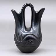 A small black wedding vase decorated with a carved stylized avanyu around the body, click or tap to see a larger version