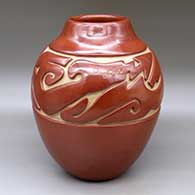 A red jar carved with an avanyu and geometric design around the shoulder
 by Jennie Trammel of Santa Clara