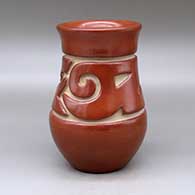 A red vase with a recurved neck and carved around the neck with a two panel stylized avanyu design
 by Jennie Trammel of Santa Clara