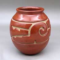 A red jar with a flared rim and carved around the shoulder with a stylized avanyu design
 by Jennie Trammel of Santa Clara