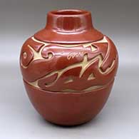 A large red jar with a short neck and carved around the shoulder with an avanyu design
 by Jennie Trammel of Santa Clara