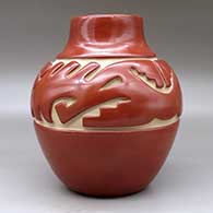 A red jar carved around the shoulder with an avanyu and geometric design, click or tap to see a larger version