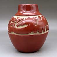 A red jar carved around the shoulder with an avanyu and geometric design, click or tap to see a larger version
