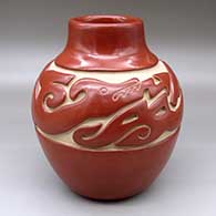 A red jar carved around the shoulder with an avanyu and geometric design
 by Jennie Trammel of Santa Clara