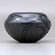 A black jar with a notched rim and carved with an elk and a bighorn  ram design around the body, click or tap to see a larger version