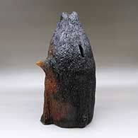 A large brown bear piggy bank with fire clouds and pinon pitch coating, click or tap to see a larger version