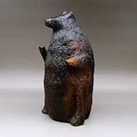 A large brown bear piggy bank with fire clouds and pinon pitch coating, click or tap to see a larger version