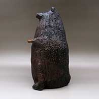 A large brown bear piggy bank with fire clouds and pinon pitch coating, click or tap to see a larger version