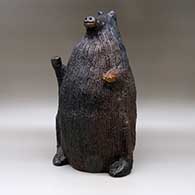 A large brown bear piggy bank with fire clouds and pinon pitch coating, click or tap to see a larger version