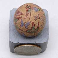 A miniature polychrome seed pot decorated with a sgraffito and painted butterfly, flower and geometric design
 by Joseph Lonewolf of Santa Clara