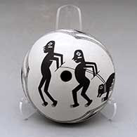 A black on white seed pot decorated with a pair of Mimbres hunters leading a bear on a leash
 by Emma Lewis of Acoma