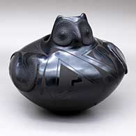 A black-on-black owl effigy jar decorated with wing appliques and geometric designs, 1998 First Place Ribbon from New Mexico State Fair
 by Jesus Quezada of Mata Ortiz and Casas Grandes