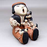 A sitting grandfather storyteller figure with five children
 by Ada Suina of Cochiti