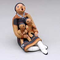 A sitting grandmother storyteller figure with two children 
 by Mary Lucero of Jemez