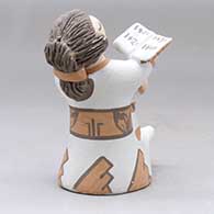 A grandmother holding a math book open and singing with the three children in her lap, click or tap to see a larger version