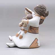 A grandmother holding a math book open and singing with the three children in her lap, click or tap to see a larger version